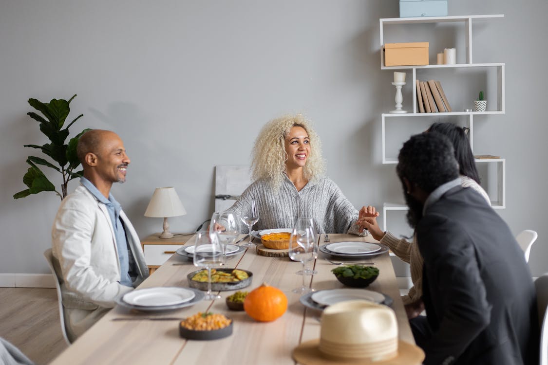 group of happy people sat around a dining table