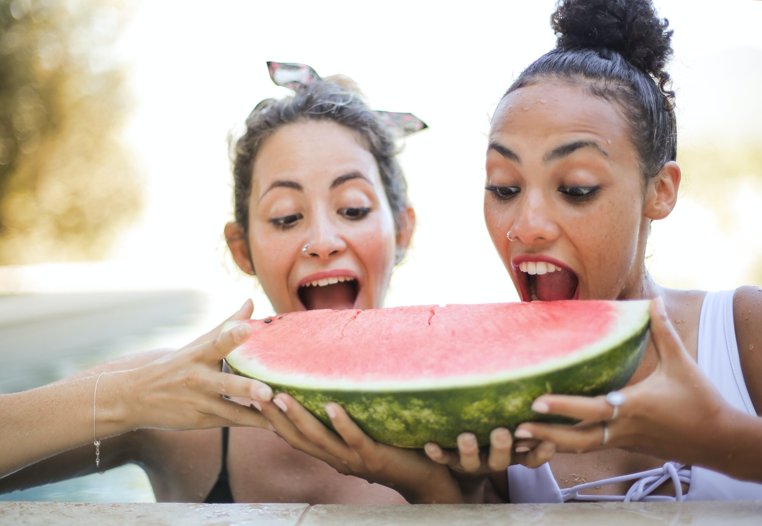 An image of two women eating a watermelon