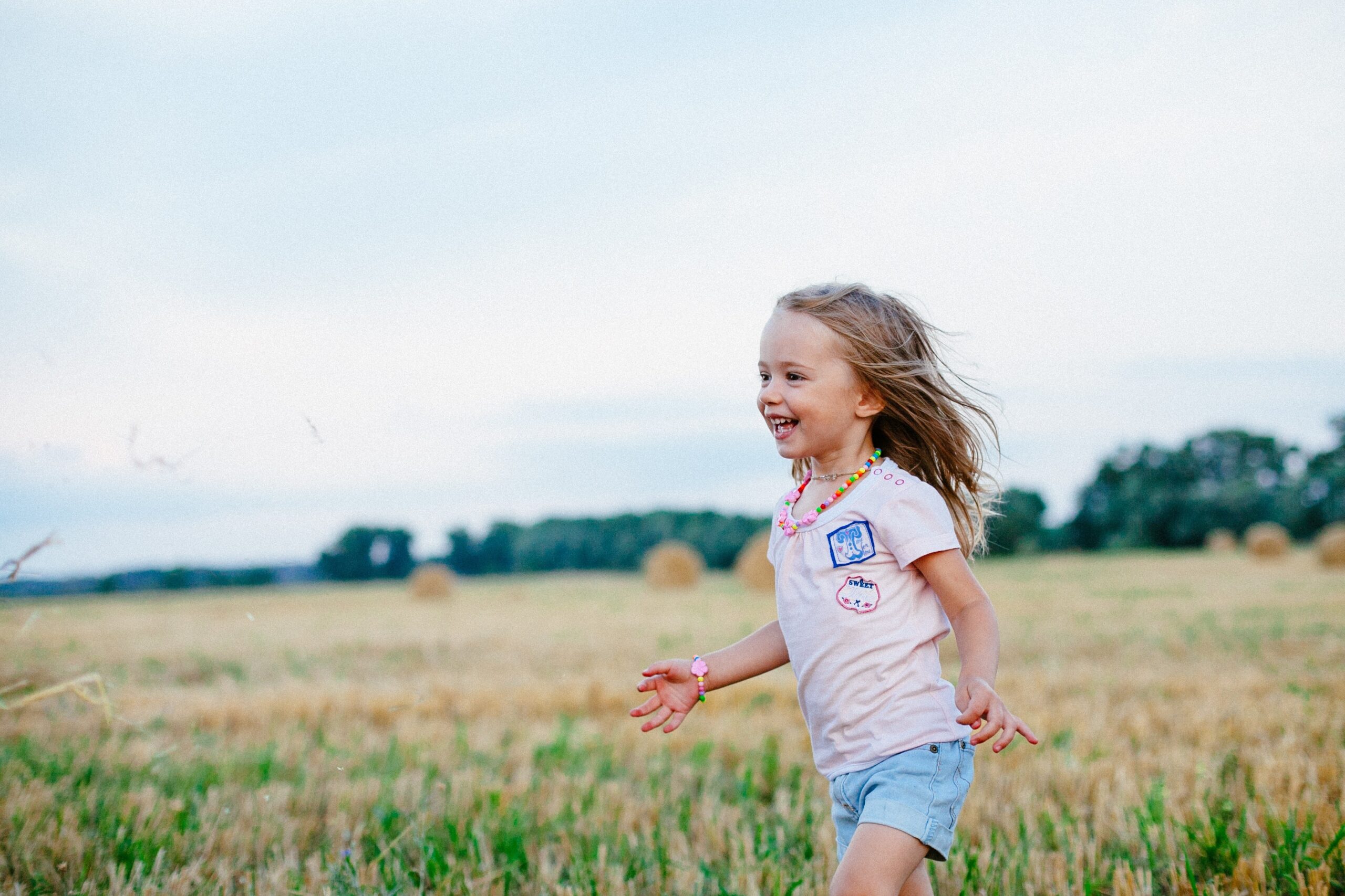 image of little girl playing in a field